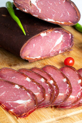 Turkish pastrami on a white background. Whole and sliced pastrami. pastrami is made from the ribeye and beef fillet parts of the cow. Local name pastırma