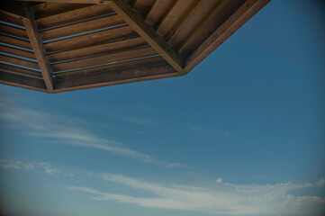 Wooden beach umbrellas close up by the sea in clear weather