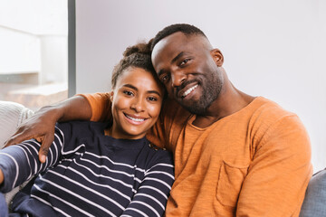 Young happy couple smiling and sitting on couch