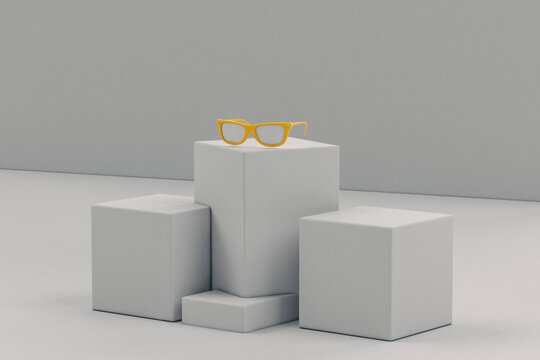 Yellow sunglasses on grey parallelepiped