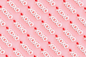 XOXO - Hugs and kisses abbreviation- 3D render of the word "XOXO" on a pink background with red hearts 