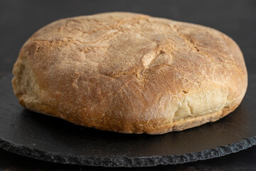 Organic round bread on a dark wooden background