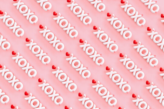 XOXO - Hugs and kisses abbreviation- 3D render of the word "XOXO" on a pink background with red hearts 
