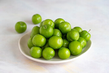 Green plum on a white background.