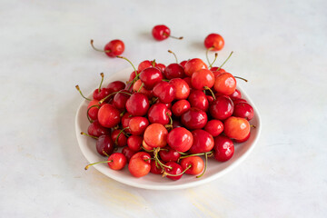 Obraz na płótnie Canvas Ripe cherries on a white background. cherry on plate