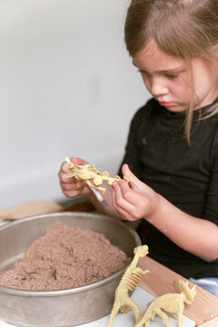 little girl excavating dinosaur skeleton