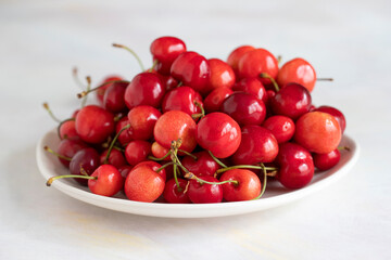 Ripe cherries on a white background. cherry on plate