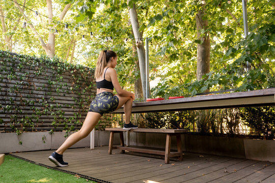 Fit woman training and stretching out in backyard at home