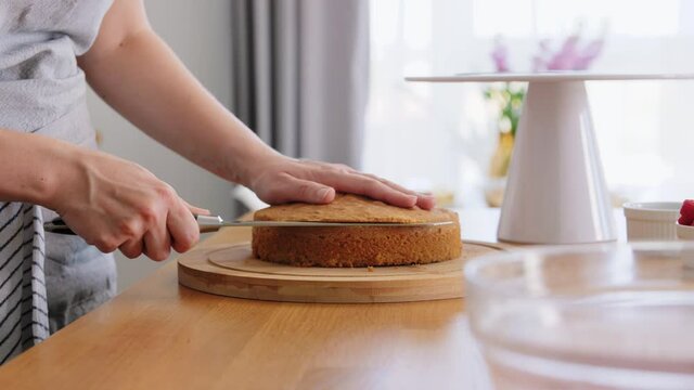 culinary, baking and cooking food concept - young woman making layer cake on kitchen at home