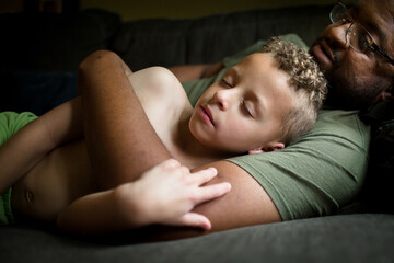 Sleeping boy cradled in father's arms
