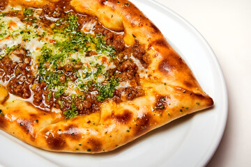 Khachapuri meat on a white plate. Close-up, selective focus