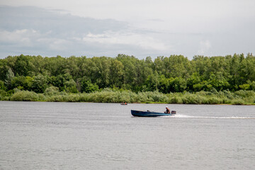 Obraz premium the motor boat goes along the river