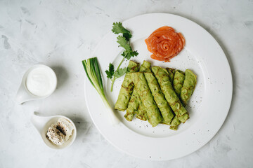 Spinach green Crepes with salmon on white background