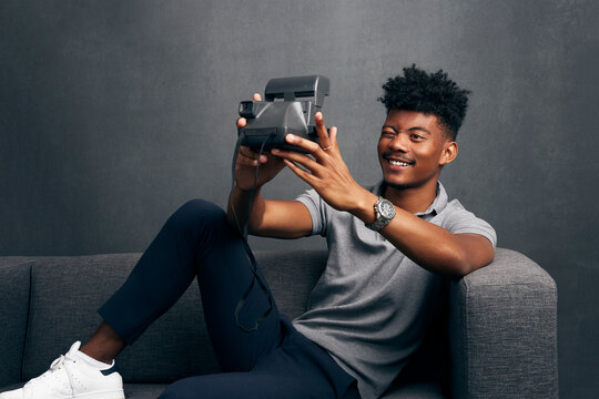 A Handsome Kenyan-Filipino Man Using An Instant Film Camera In Studio