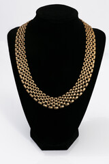 A gold chain on a black bust isolated on white background