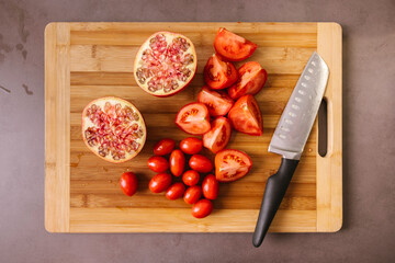 Ripe tomatoes and pomegranate on cutting board