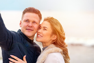 Obraz premium Happy romantic Smiling couple taking selfie on the sunny beach