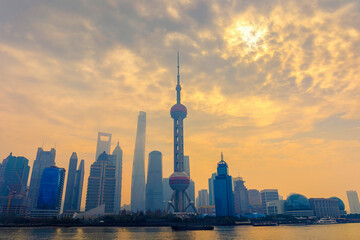 Fototapeta premium Shanghai skyline in sunny morning with cloud sky, misty and Huangpu river cityscape view