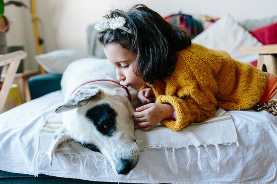 Little girl kissing her dog