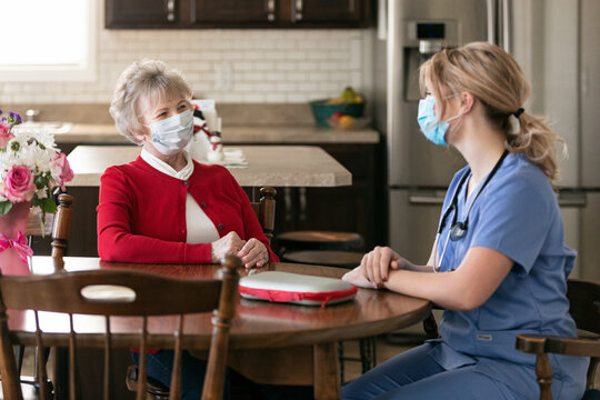 Health: In Home Care Nurse Talks With Senior Woman