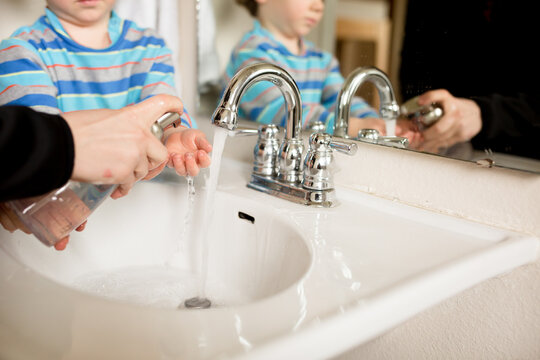 Mother puts soap on boy's hands