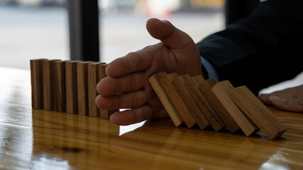 business risk investment concept Businessmen protecting blocks from falling down plans and strategies jeopardize construction business and insure investments.