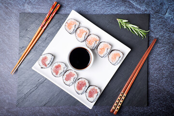 Naklejka premium Top view of a plate with sushi and its wooden chopsticks. Asian food. Healthy food concept