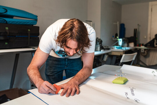 Textile designer using an eraser to mark fabric