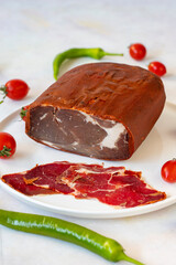 Turkish pastrami on a white plate. Sliced beef bacon. local name kayseri pastırma