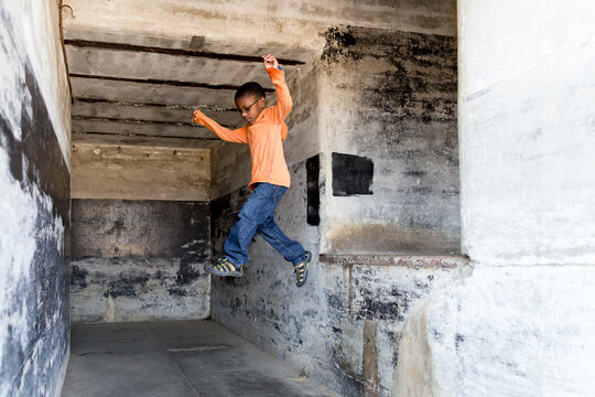 Boy jumps from concrete ledge 