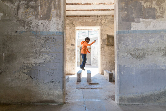 Agile boy hops across concrete blocks