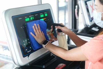 partial view of woman cleaning sports equipment in gym on blurred foreground	