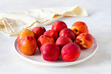Ripe fresh nectarine on a white ceramic plate