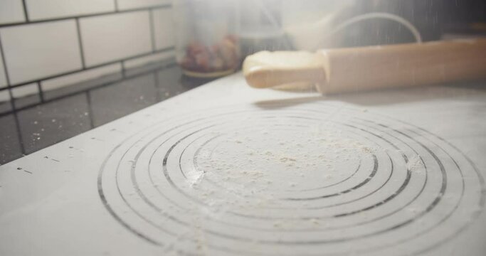 Close up hands of bakery Chef preparing applying flour and kneading roll out dough with a rolling pin on the table, Ingredients and preparation stages for cooking making bread cake at kitchen