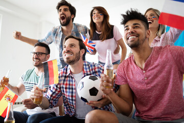 Group of friends having fun at home, watching game and enjoying together.