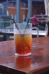 a glass of iced tea with straw