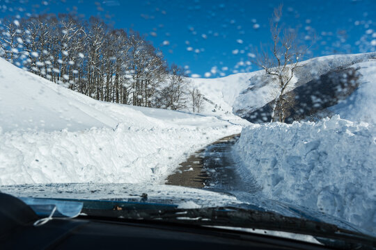 car on narrow snow cleared road 