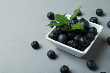 Fresh blueberry with leaves on gray background