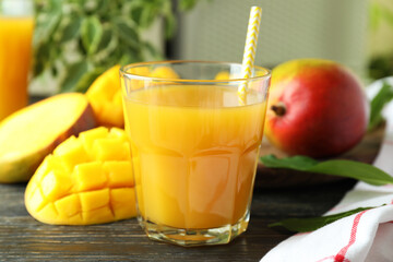 Ripe mango fruit and juice on wooden table