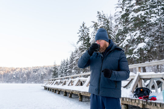 Man Drinking Tea At Frozen Lake