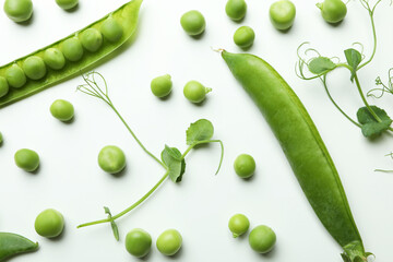 Green pea pods, seeds and twigs on white background
