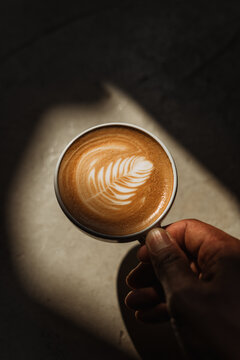 A cup of Coffee latte on the Cement floor in sunlight