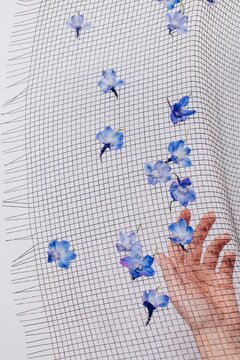 Female hand under mesh napkin with flowers
