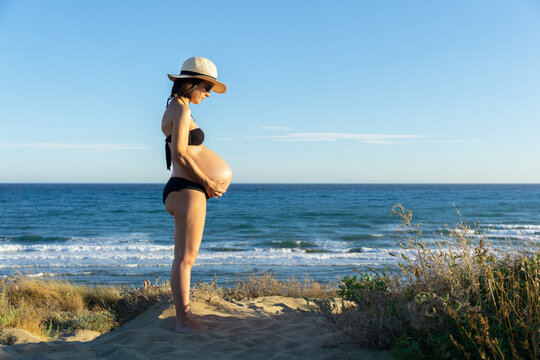 Pregnant young woman sunbathing on the beach