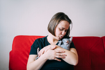 Woman hugging kitten at home