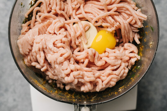 Food processor filled with ground chicken, shawarma spices, and an egg