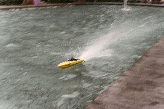 Remote control toy boat splashing water in pool
