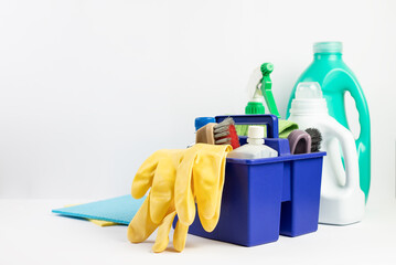Cleaning gloves and various bottles with detergent on a white background
