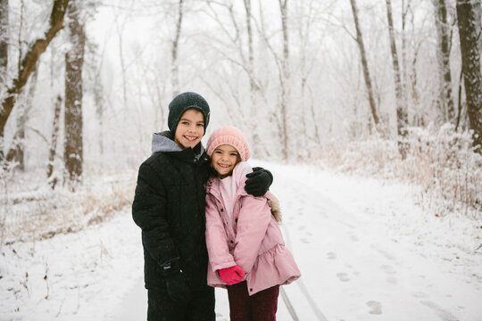 kids hug in snowy woods