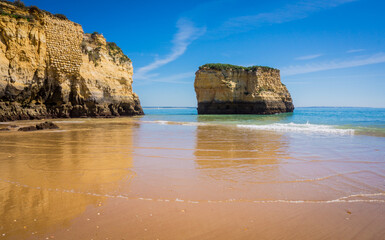Naklejka premium Cliffs of Praia da Dona Ana, sandy beach with clear blue water on a sunny day, no people, Lagos, Algarve, Portugal